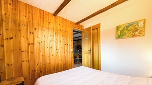 Ein Schlafzimmer mit einer Holzwand, einem Bett, einem Sessel und einer Karte an der Wand.