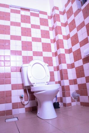 Ein Badezimmer mit Toilette, Bidet und gefliesten Wänden.