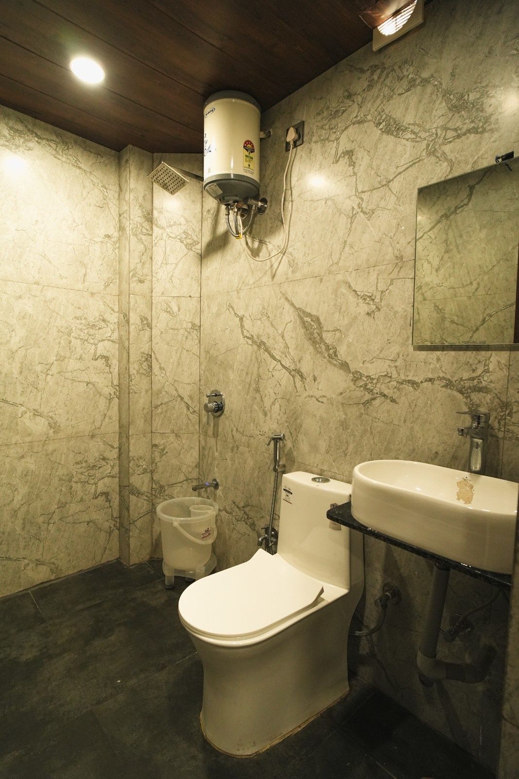 A bathroom with a toilet, bidet, and a sink.