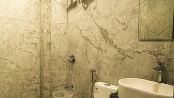 A bathroom with a toilet, bidet, and a sink.