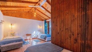 A cozy bedroom with two beds, wooden ceiling beams, and a large window. - Lodge Los Naranjos de Mallarauco  (Melipilla)