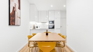 A modern kitchen with white cabinets, a microwave, and an oven.