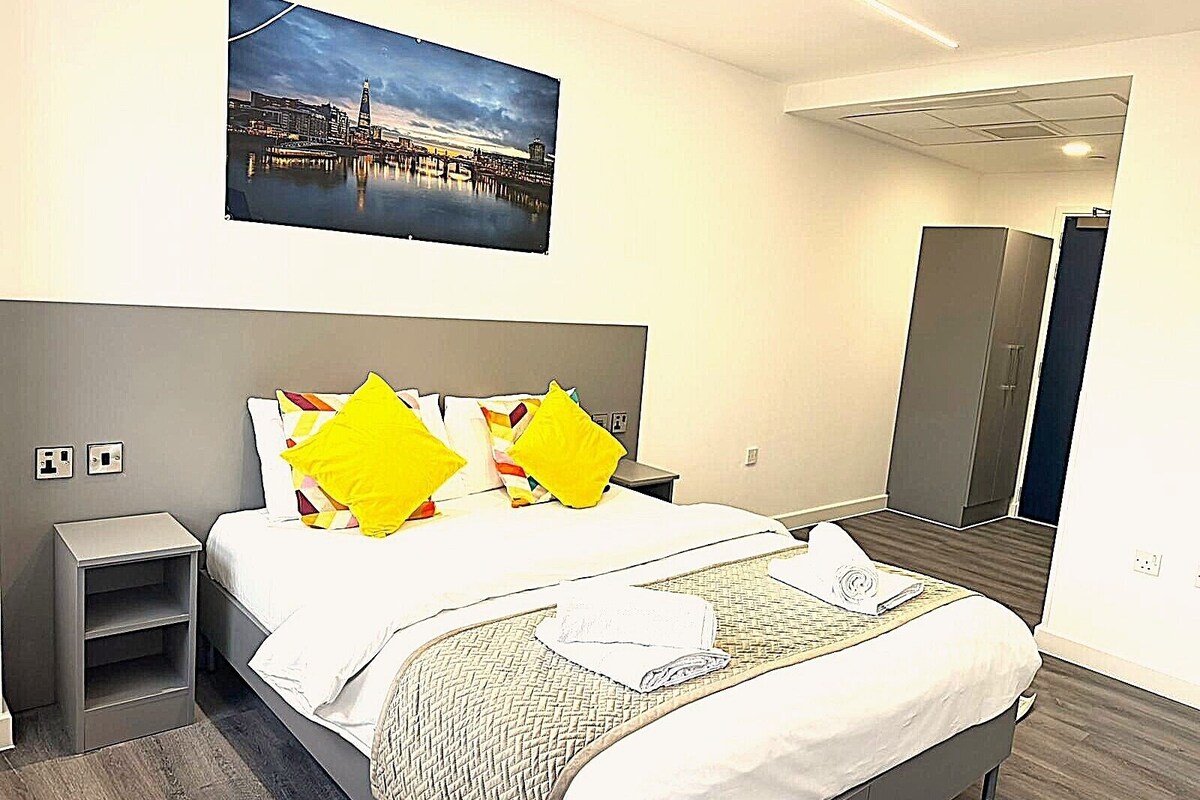Ein Hotelzimmer mit Bett, Nachttisch, Schrank und einem Stadtbild.
