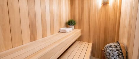 Un sauna con bancos de madera y una pared de piedra.