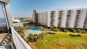 Ein Hotel mit Poolbereich, mehreren Balkonen und Meerblick.