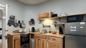 Une cuisine avec des meubles en bois, un réfrigérateur en acier inoxydable et un four à micro-ondes.