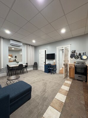 A modern kitchen with a stove, oven, and hanging pots.