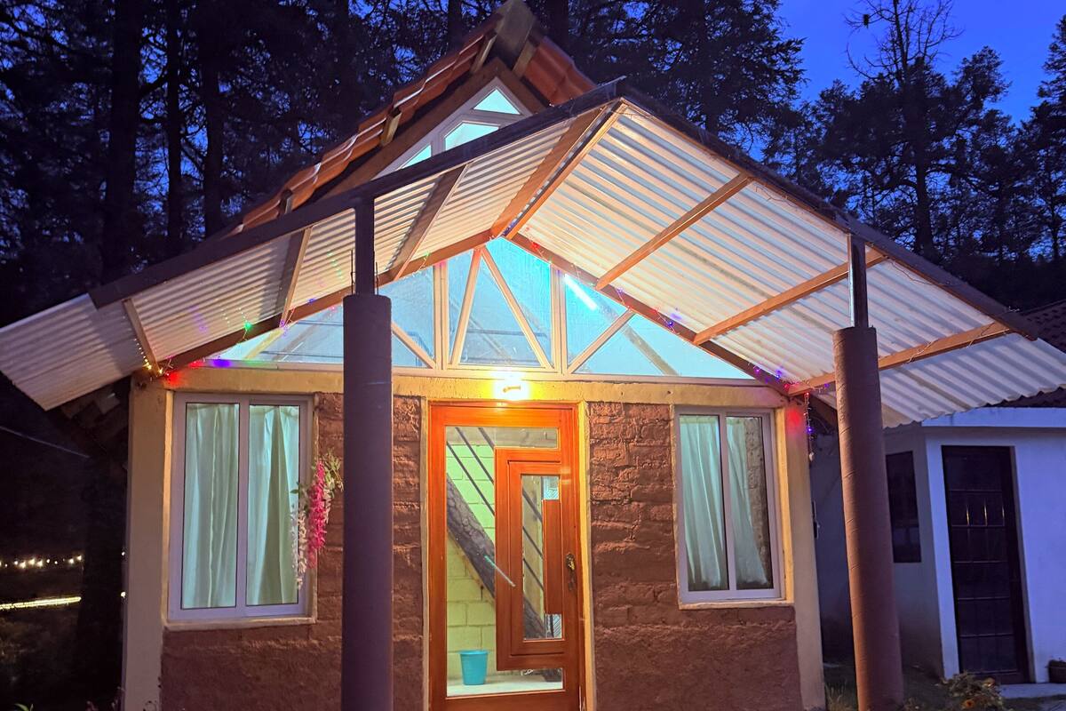 Una casa con techo inclinado, puerta de madera y un pequeño porche.