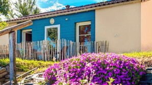 Een huis met een blauwe gevel en een houten omheining.