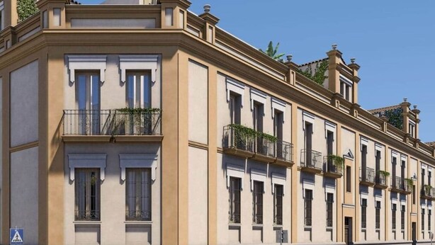 A multi-story building with a classic architectural style, featuring balconies with plants, large windows, and a uniform facade. - Jupiter, apartment in historic building in San Roque neighborhood (Seville)