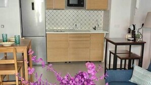 Una cocina moderna con armarios de madera, microondas y refrigerador.