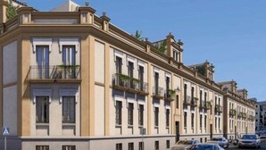 Un edificio de varios pisos con un estilo arquitectónico clásico, que presenta ventanas y balcones simétricos.