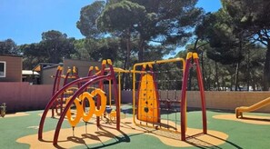 Un parque infantil con diversas estructuras de juego, incluyendo columpios, toboganes y zonas de escalada.