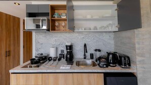 A modern kitchen with built-in appliances, wooden cabinets, and a marble countertop. - Michoacan Space Lovely Apartment With Balcony (Mexico City)