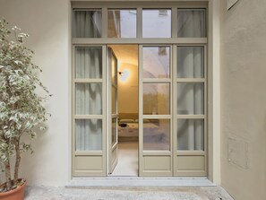 A room with a bed, a nightstand, and a potted plant. - Loft Portici in Torino (Turin)