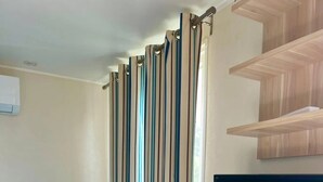 Un soggiorno moderno con un divano blu, una televisione a schermo piatto e una libreria in legno.