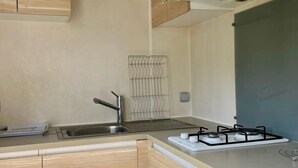 Una cucina moderna con mobili in legno, un lavello in acciaio inossidabile e un piano cottura a gas.