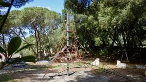 Eine Metallkonstruktion in einem bewaldeten Gebiet, möglicherweise eine Klettervorrichtung oder Spielgerät.