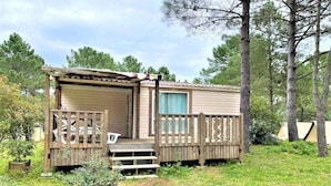 A mobile home with a covered porch and a fenced deck area. - ZEcamping 3 étoiles piscine locatif clim 35m2 6 pers (Sartène)