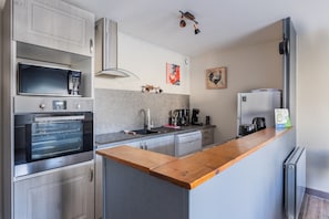 Eine moderne Küche mit integrierten Geräten, einer Holzarbeitsplatte und einem Kühlschrank.