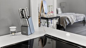 Une chambre d’hôtel au design moderne, dotée d’un coin cuisine avec un plan de travail en marbre, un bloc à couteaux et un petit porte-bougie.