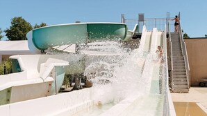A water slide with a person at the top and another at the bottom. - ZEcamping 4* espace bien-être avec jacuzzi et sauna cadre verdoyant (Caro)