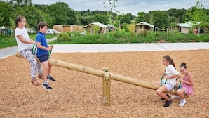 Une balançoire dans un parc où des enfants jouent.