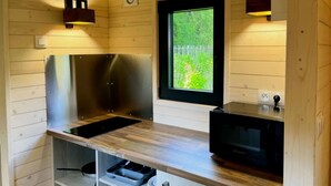 Eine kompakte Küche mit Einbauherd, Mikrowelle und Holzschränken.