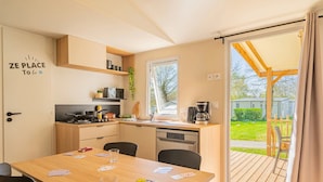 Een compacte keuken met een eethoek, een koffiezetapparaat en uitzicht op het omliggende landschap.