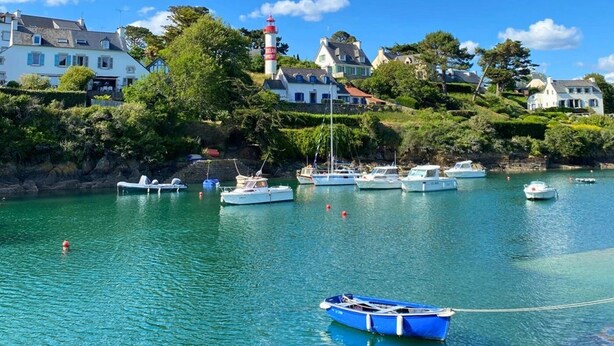 A coastal scene with a lighthouse, boats, and houses along the shore. - ZEcamping 4 étoiles familial espace aquatique mobil-home TV 35m2 (Guidel)