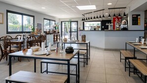 A modern cafe with wooden tables and chairs, a counter with a menu, and large windows offering a view of the outdoors. - ZEcamping 4 étoiles familial espace aquatique mobil-home TV 35m2 (Guidel)