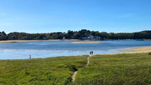 A coastal landscape with a clear sky, a sandy beach, and a grassy area with a path. - ZEcamping 4 étoiles familial espace aquatique mobil-home TV 35m2 (Guidel)