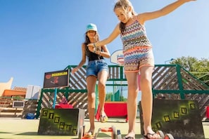 Two individuals on a playground with a basketball hoop and a sign that reads 'DIABOLOS'. - ZEcamping 4* animé piscine chauffée tente TV BBQ clim 26m2 (Canet-en-Roussillon)