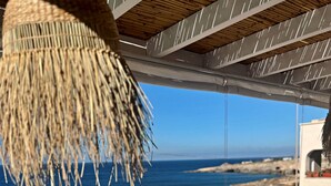 A terrace with outdoor furniture, a table, and a hanging light fixture. - Villetta Costa Azure - Con Piscina Vista Mare (Castrignano del Capo)