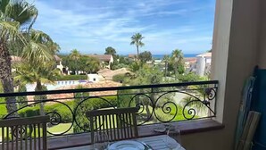 Ein Balkon mit Esstisch, der einen schönen Ausblick auf Palmen und Häuser bietet.