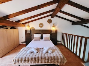 A bedroom with a wooden ceiling, a bed with white linens, two wall sconces, and a wooden railing. - T3 sea view for 4 people, walking distance to beach, swimming pool (Linguizzetta)