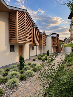 A modern residential building with a sloped roof and wooden lattice facade. - Rostrini Family Home Alpine Retreat with Mountain View (Cavalese)