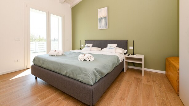 Ein Schlafzimmer mit Bett, Nachttisch und einem Bild an der Wand.