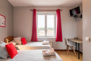 A hotel room with two beds, a desk, a chair, a TV, and a window with curtains. - Double Room 21 in Somo (Somo)