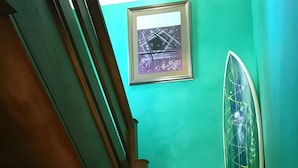 A wooden staircase with a green wall and a framed picture above it. - Habitación Doble 24 en Somo: Confort y Balcón Privado (Somo)