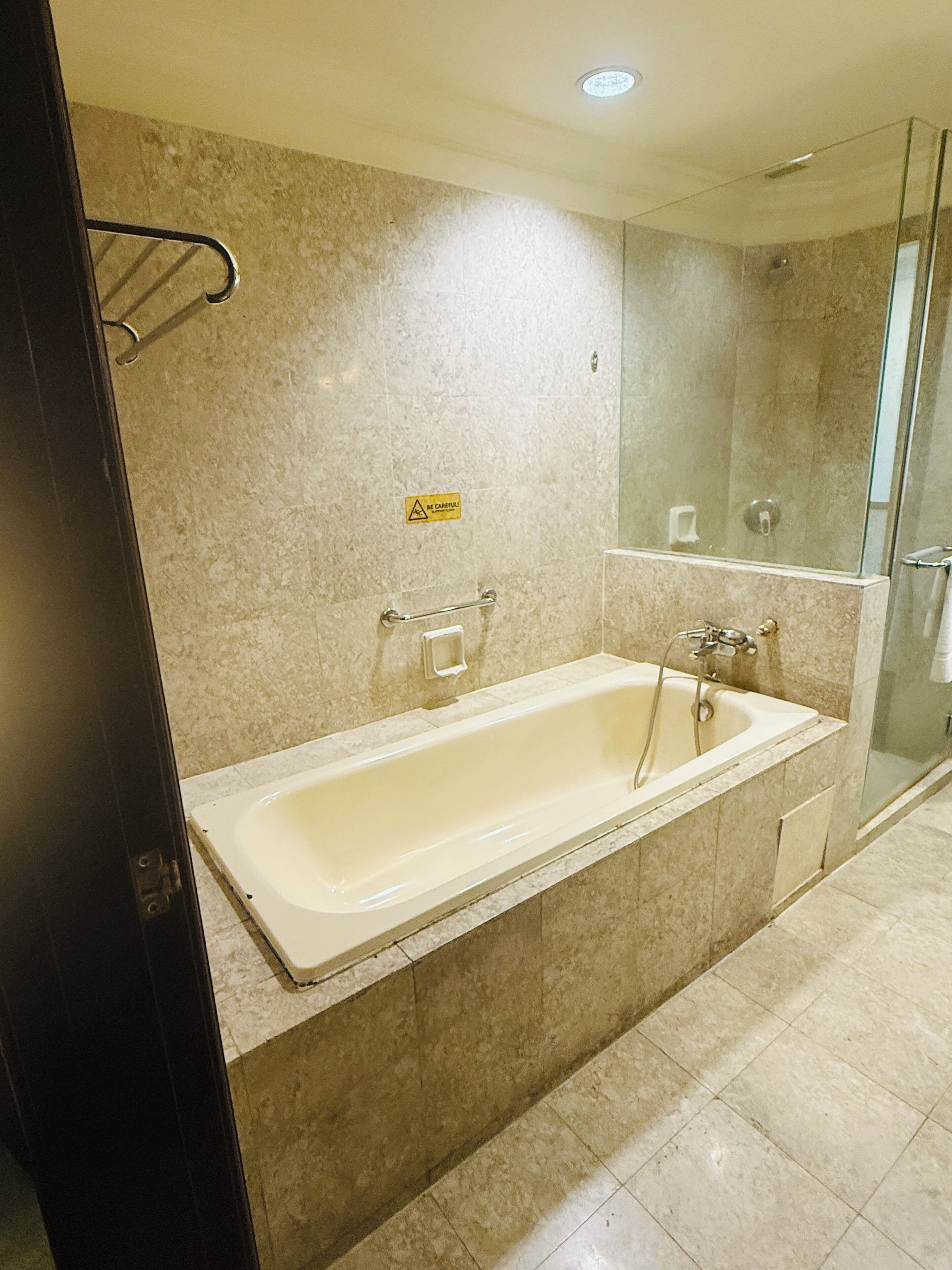 Un baño con bañera, ducha y cabina de ducha de vidrio.