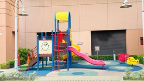A playground with a slide, climbing structures, and a yellow and red play area. - Alpha Suite at times square  (Kuala Lumpur)
