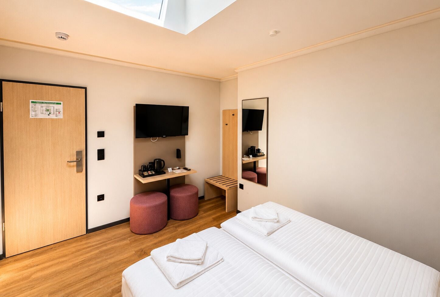 Une chambre d’hôtel comprenant un lit, un bureau avec un téléviseur à écran plat, une machine à café et un miroir.