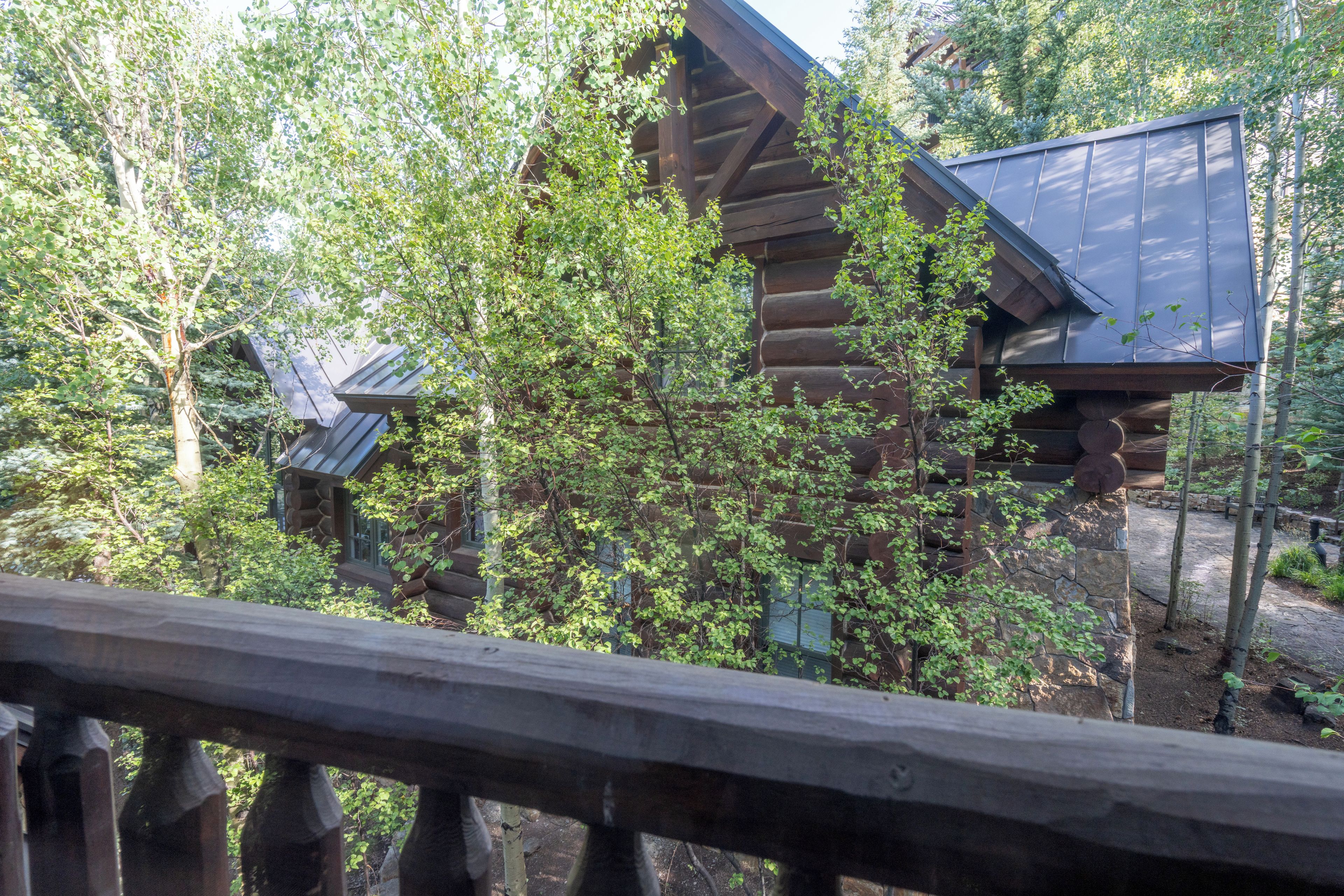 A wooden cabin with a sloped roof surrounded by trees.
