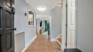 A hallway with a dark door, a white door, and a bench. - Heritage Hideaway ~ Sea Pines renovated dog-friendly condo (Hilton Head Island)