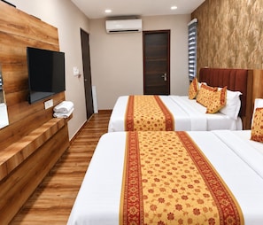 Una habitación de hotel con dos camas, un televisor y un banco de madera.