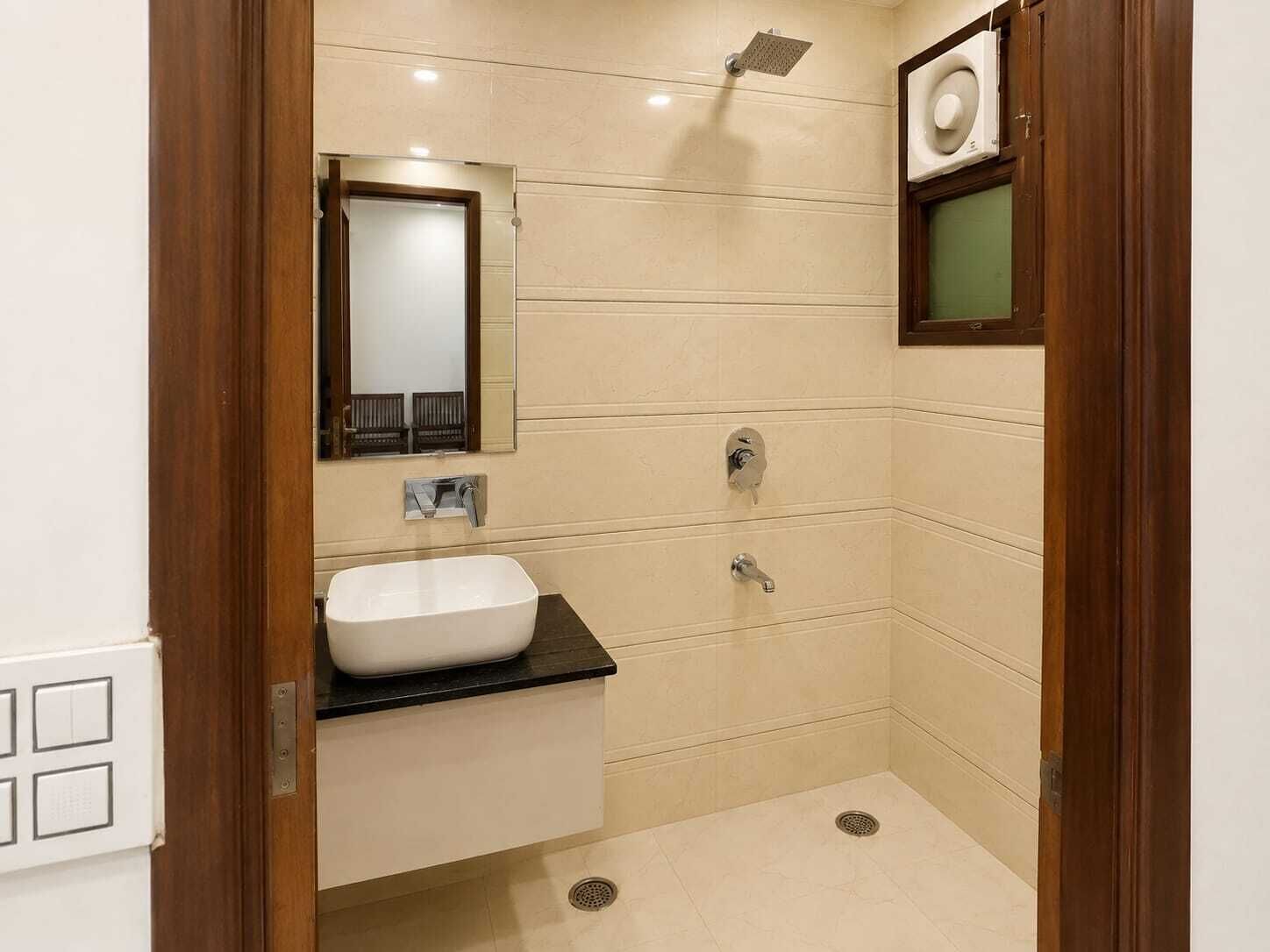 A bathroom with a white sink, a mirror, a shower, and a toilet.