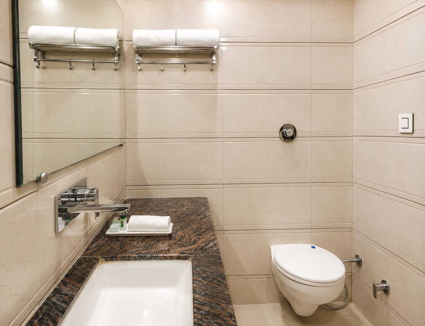 Un baño con bañera, inodoro y toalleros.