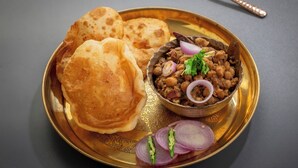 Un piatto con chapati, una ciotola di dal e cipolle a fette.
