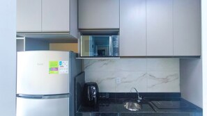 A kitchen with a refrigerator, microwave, coffee maker, and sink. - Waikiki Garden - Porto de Galinhas (Ipojuca)